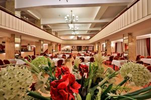 a banquet hall with white tables and red flowers at Belvedere in Prague