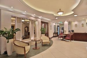 a lobby with chairs and tables and a salon at Retro Riverside Wellness Resort in Karlovy Vary +81 photos