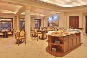 a restaurant with tables and chairs and a buffet at Retro Riverside Wellness Resort in Karlovy Vary