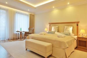 a large bedroom with a large bed and a chair at Retro Riverside Wellness Resort in Karlovy Vary