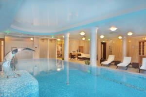 a swimming pool with a dolphin in a hotel room at Retro Riverside Wellness Resort in Karlovy Vary