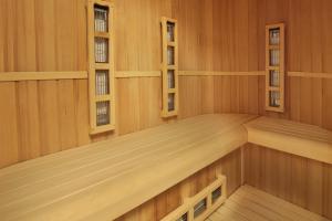 an empty sauna with wood paneling and windows at Retro Riverside Wellness Resort in Karlovy Vary