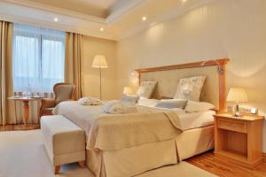 a large bedroom with a large bed and a chair at Retro Riverside Wellness Resort in Karlovy Vary