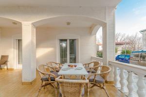 a porch with a table and chairs on a balcony at Apartments Ivica - with parking in Nin