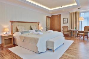 a bedroom with a large bed and a living room at Retro Riverside Wellness Resort in Karlovy Vary