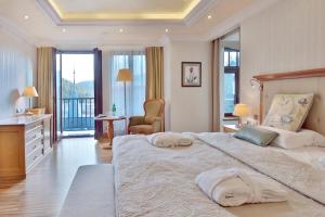 a bedroom with a large bed with two towels on it at Retro Riverside Wellness Resort in Karlovy Vary