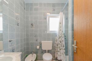 a bathroom with a toilet and a sink and a window at Apartments Ivica - with parking in Nin