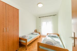 a bedroom with two beds and a cabinet at Apartments Ivica - with parking in Nin