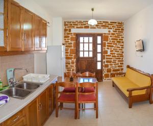 una cocina con fregadero y un sofá en una habitación en PETRA-MARE 6, en Triopetra