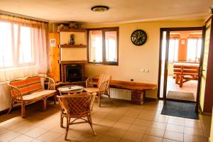 a living room with a table and chairs and a clock at Piatra Rancii in Ranca