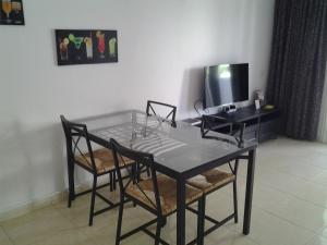 stół jadalny z krzesłami i telewizor w obiekcie Paraiso Royal Dany & Pina w Playa de las Americas