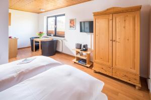 1 dormitorio con 1 cama y armario de madera en Birkenhof, en Norderney