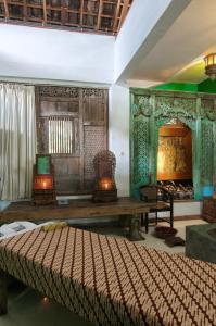a living room with a bed and a fireplace at Hotel Tugu Blitar in Blitar
