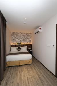 a bedroom with a bed and a wall at Double M Hotel @ Kl Sentral in Kuala Lumpur