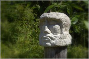 una estatua de piedra de una cara en un poste en Ferienwohnung Fohrmann, en Haffkrug