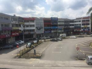 a parking lot with cars parked in front of buildings at Desa house hotel in Kampong Kepong