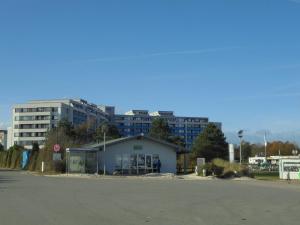 a building in a parking lot with buildings in the background at Ostseemuschel in Damp