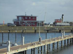 ein Dock mit einem Yachthafen und einem roten Gebäude in der Unterkunft Ostseemuschel in Damp