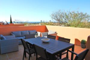 マルベーリャにあるFantastic Sea And Golf View Apartmentのパティオ(テーブル、椅子、ソファ付)
