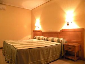 a bedroom with a bed and two lights on the wall at Hostal Benamar in Madrid