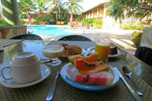 een tafel met een bord eten en twee kopjes koffie bij Hotel Laguna Blu in Aquiraz