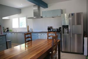 cocina con mesa de madera y nevera en ancienne ferme rénovée, en Upie