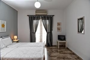 Un dormitorio con una cama grande y una ventana en Fotopoulos Apartments, en Xiropigado