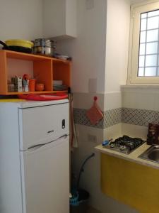 a kitchen with a white refrigerator and a sink at Appartamento Osnao in Cefalù