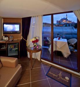 ein Wohnzimmer mit einem Tisch und einem großen Fenster in der Unterkunft GLK PREMIER Acropol Suites & Spa in Istanbul