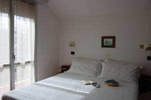 リッチョーネにあるHotel Floresのベッドルーム1室(窓、白いベッド1台付)