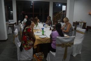 un grupo de personas sentadas en una mesa larga en Hotel Nadee, en Aluthgama
