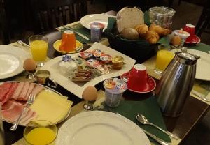 een tafel met borden eten en eieren en dranken bij Hotel Café Restaurant "De Kroon" in Wissenkerke