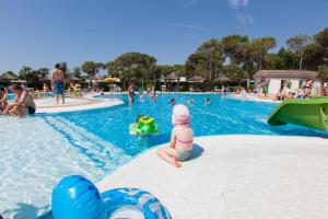 a child in the water at a swimming pool at Vela Blu Camping Village in Cavallino-Treporti +69 photos