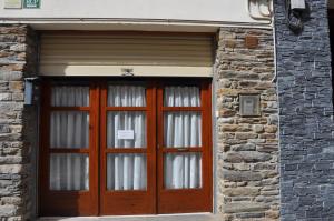 un par de puertas de madera en un edificio de ladrillo en Casa Nando, en Esterri d'Àneu