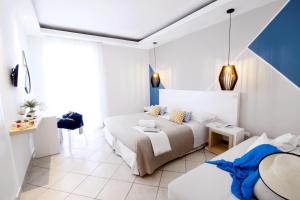 a white bedroom with a bed and a table at Hotel Rivage in Sorrento