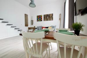 ブダペストにあるStandard Apartment by Hi5 - Wesselényi 8のダイニングルーム(木製テーブル、白い椅子付)