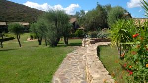einen Garten mit einem Steinpfad im Gras in der Unterkunft Vela Blu in Marinella