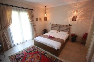 a bedroom with a bed with flowers on it at Dardanos Hotel in Patara