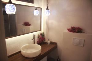 a bathroom with a sink and a mirror and lights at Dardanos Hotel in Patara