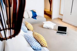 a white couch with pillows and a laptop on it at Hotel Rivage in Sorrento