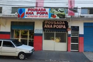 a car parked in front of a store with a dog in a window at Pousada Ana Poipa in Goiânia
