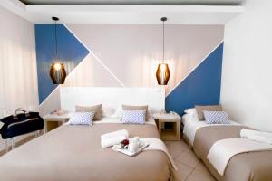 two beds in a room with blue and white at Hotel Rivage in Sorrento