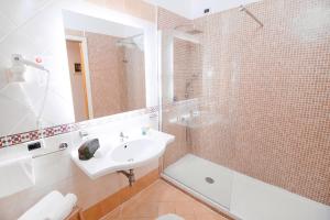 a bathroom with a sink and a shower and a tub at Hotel Rivage in Sorrento