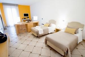 a hotel room with two beds and a desk and a desk at Hotel Rivage in Sorrento