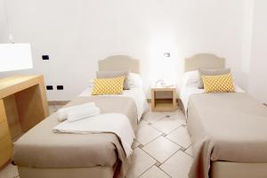a room with three beds with pillows on them at Hotel Rivage in Sorrento