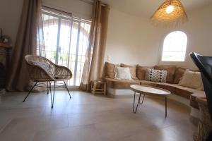 a living room with a couch and a table and chairs at Casa Acacia Mar in Cambrils