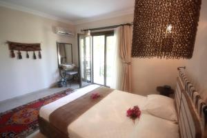 a bedroom with a bed with two flowers on it at Dardanos Hotel in Patara