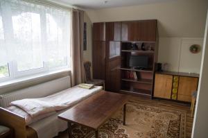 a living room with a table and a window at Viesu nams un kempings Papes Čakstes in Pape