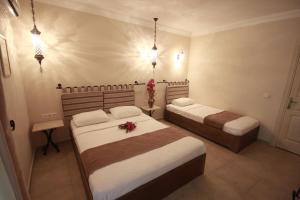 a bedroom with two beds with flowers on it at Dardanos Hotel in Patara