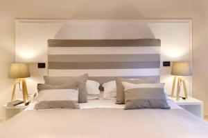 a bedroom with a large white bed with two lamps at Hotel Rivage in Sorrento